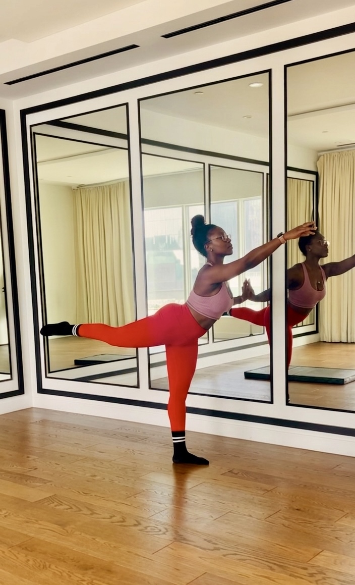 Rolake performing a barre balance pose
